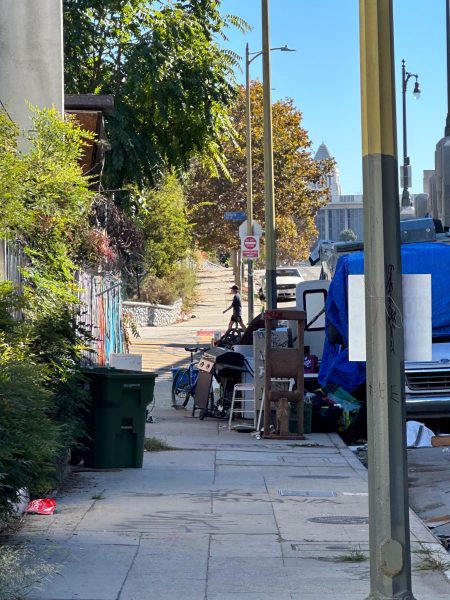 An RV parked by a sidewalk with household items.